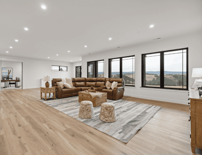 Open floor basement entertainment area with large windows allowing natural lighting